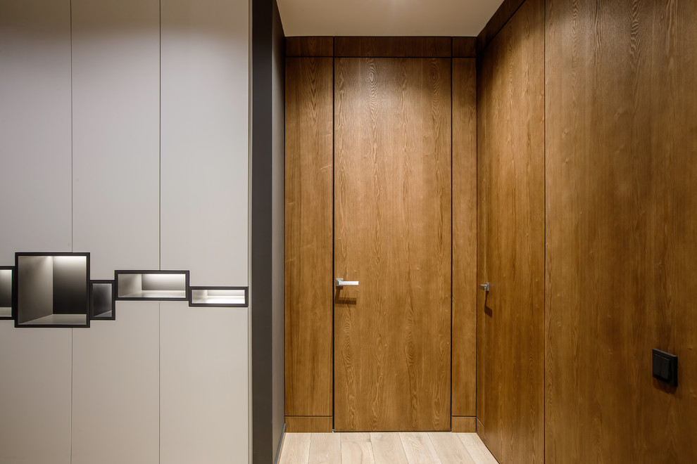Idée de décoration pour un couloir design de taille moyenne avec un mur gris et un sol en bois brun.