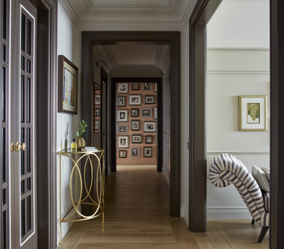 Foto de recibidores y pasillos clásicos renovados con paredes blancas, suelo de madera en tonos medios y suelo marrón