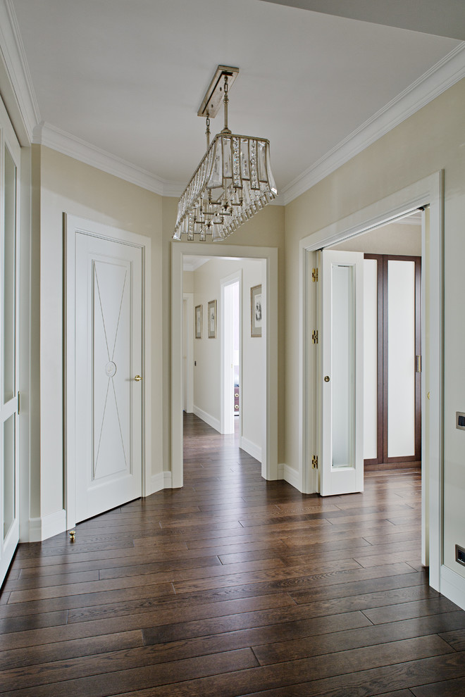 На фото: коридор в классическом стиле с белыми стенами и темным паркетным полом с