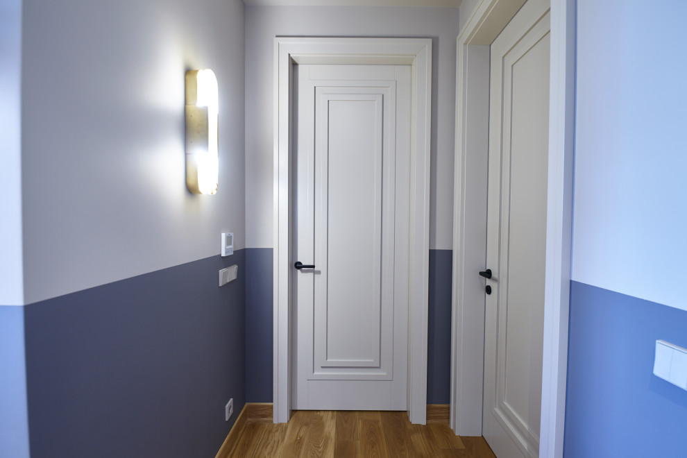 Стильный дизайн: узкий коридор среднего размера в современном стиле с белыми стенами, полом из ламината и бежевым полом - последний тренд