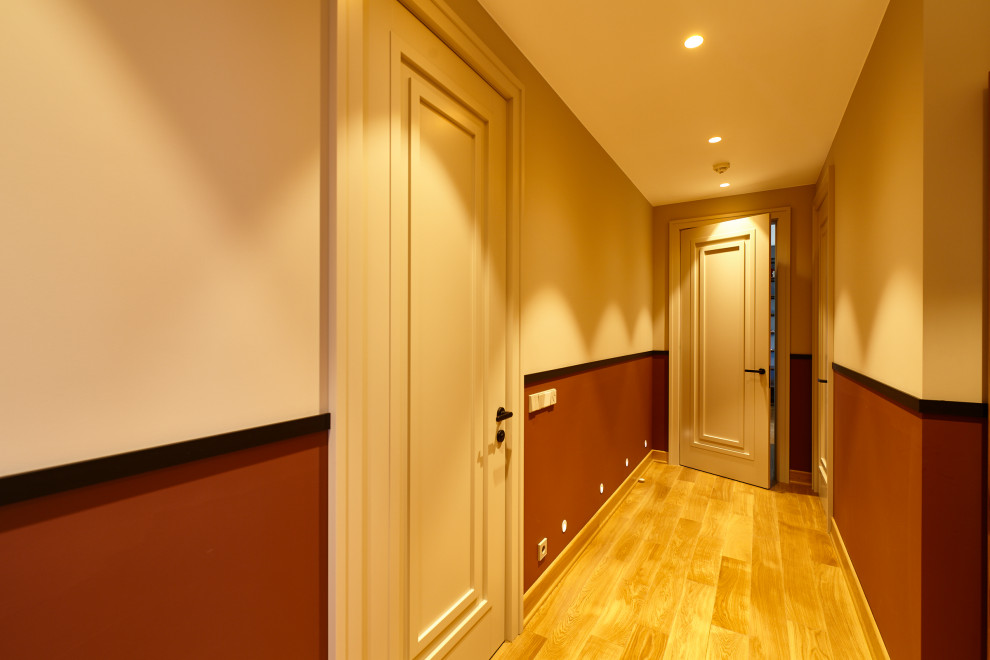 Cette photo montre un couloir tendance de taille moyenne avec un mur blanc, sol en stratifié et un sol beige.