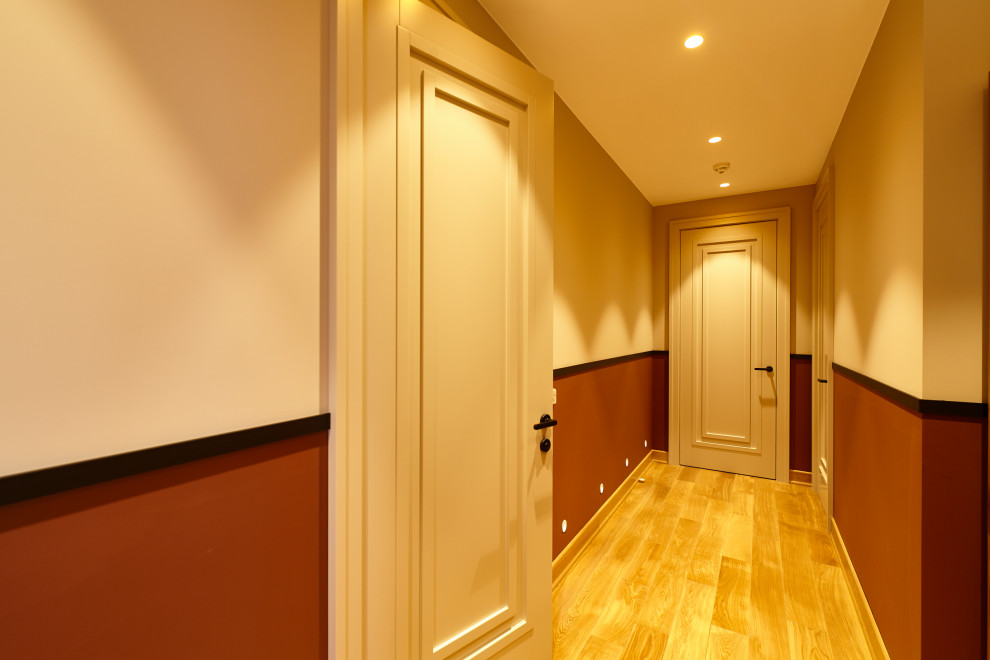 Réalisation d'un couloir design de taille moyenne avec un mur blanc, sol en stratifié et un sol beige.