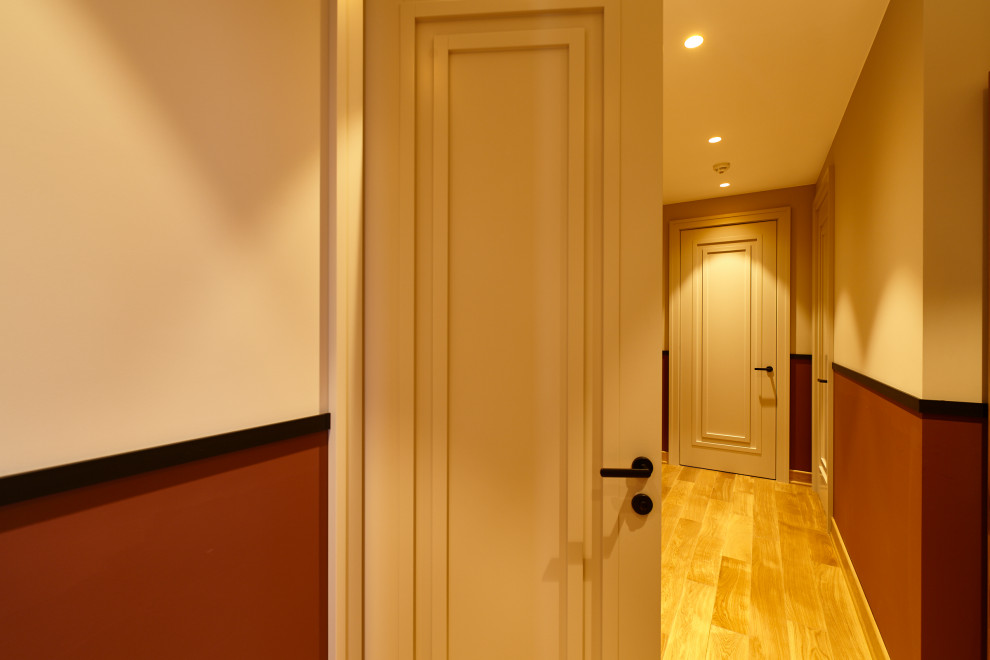 Inspiration pour un couloir design de taille moyenne avec un mur blanc, sol en stratifié et un sol beige.
