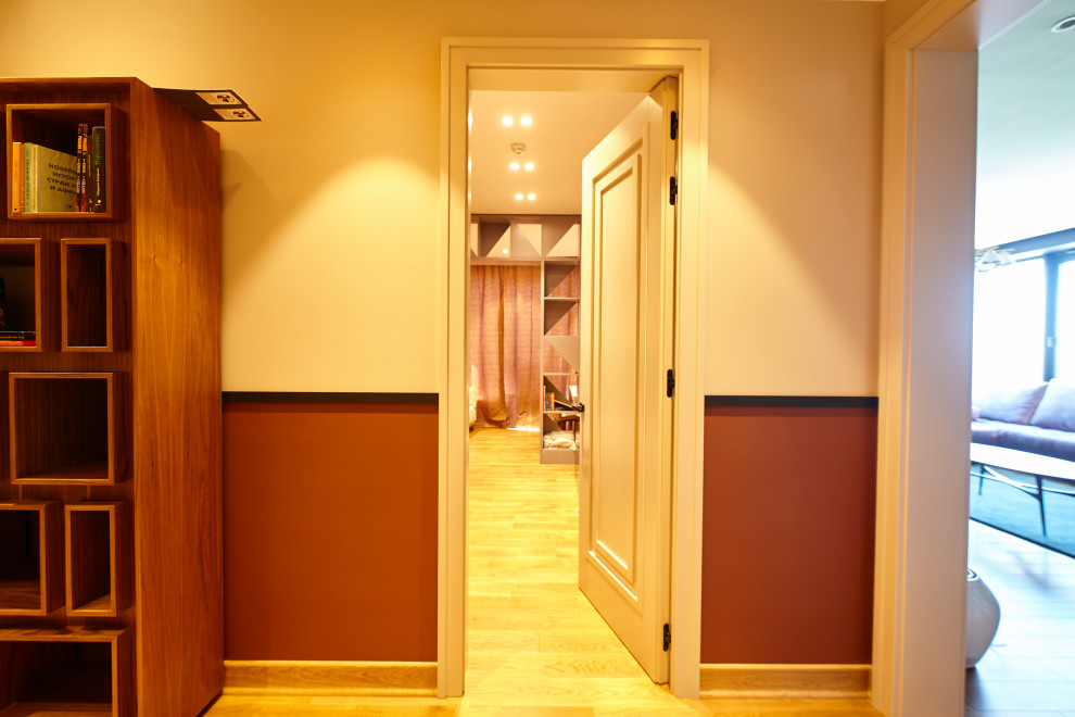 Exemple d'un couloir tendance de taille moyenne avec un mur blanc, sol en stratifié et un sol beige.