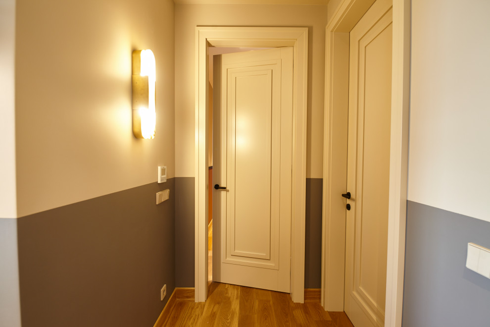 На фото: узкий коридор среднего размера в современном стиле с белыми стенами, полом из ламината и бежевым полом с