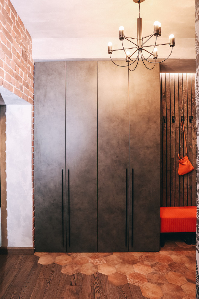 Mid-sized urban dark wood floor, brown floor and brick wall hallway photo in Other