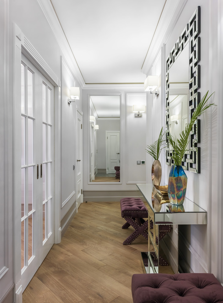 Modelo de recibidores y pasillos tradicionales renovados con paredes blancas, suelo de madera en tonos medios y suelo marrón