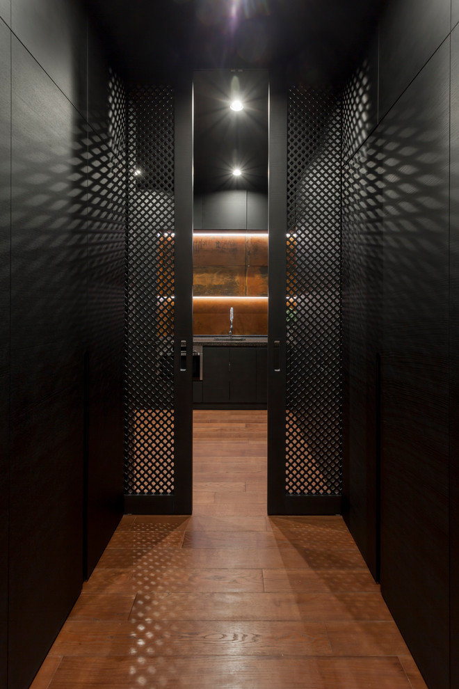 Immagine di un ingresso o corridoio contemporaneo con pareti nere e pavimento in legno massello medio