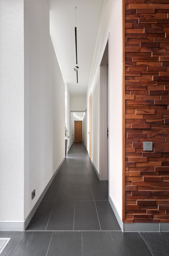 Свежая идея для дизайна: большой коридор в современном стиле с белыми стенами и серым полом - отличное фото интерьера