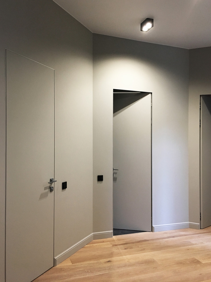 Идея дизайна: коридор среднего размера в современном стиле с серыми стенами, паркетным полом среднего тона и бежевым полом