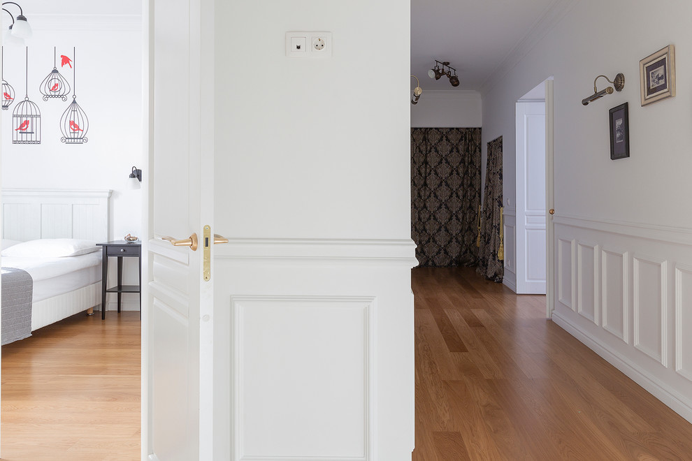 Свежая идея для дизайна: коридор среднего размера в скандинавском стиле с белыми стенами, полом из ламината и коричневым полом - отличное фото интерьера