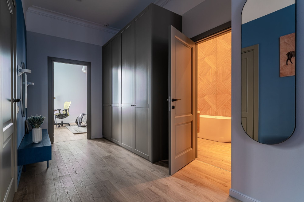 Стильный дизайн: коридор среднего размера в скандинавском стиле с синими стенами, полом из ламината, коричневым полом, многоуровневым потолком и обоями на стенах - последний тренд