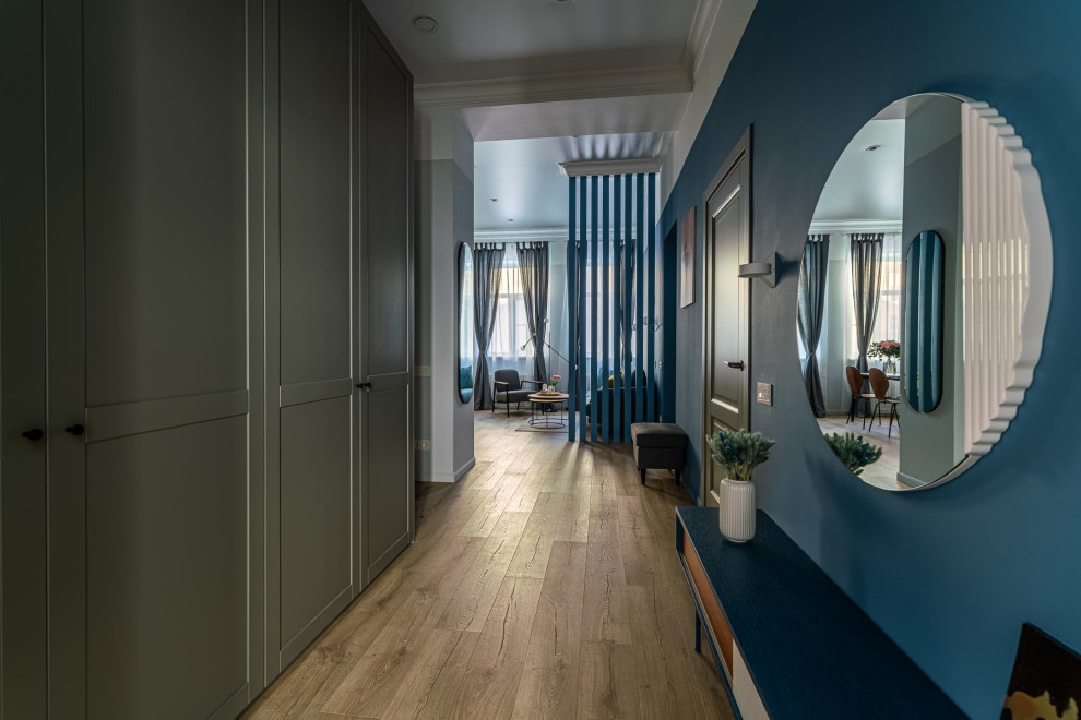 Modelo de recibidores y pasillos escandinavos de tamaño medio con paredes azules, suelo de madera en tonos medios, suelo marrón, bandeja y papel pintado