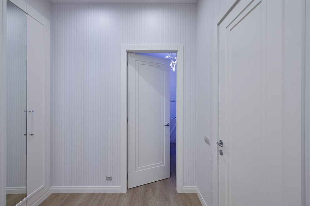 Пример оригинального дизайна: коридор среднего размера в стиле неоклассика (современная классика) с белыми стенами, полом из ламината и бежевым полом