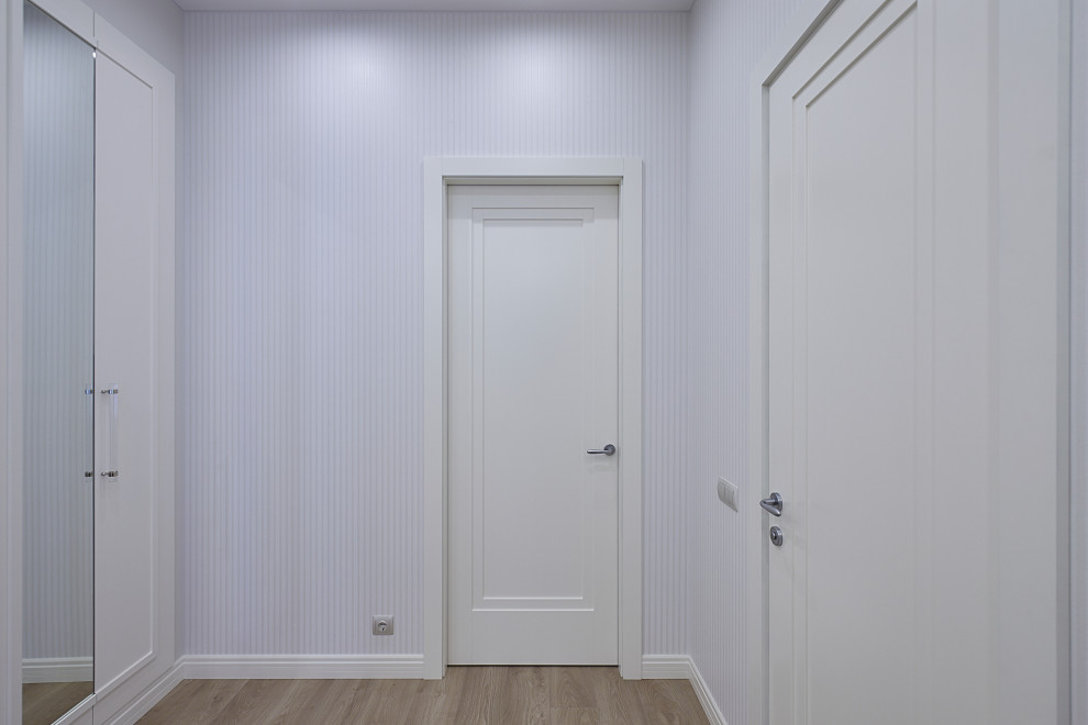 Стильный дизайн: коридор среднего размера в стиле неоклассика (современная классика) с белыми стенами, полом из ламината и бежевым полом - последний тренд
