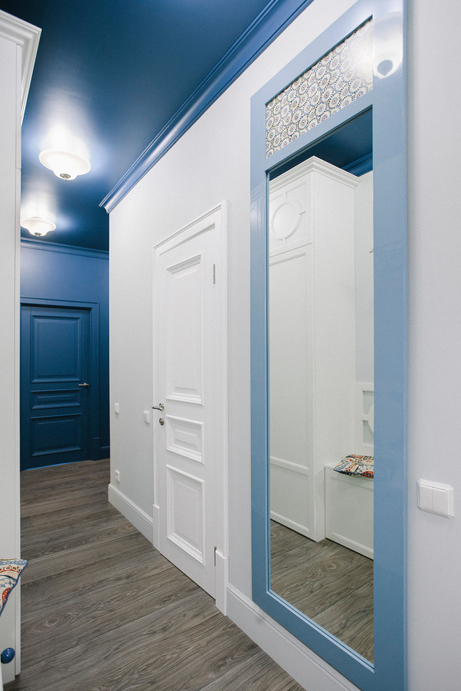 Immagine di un ingresso o corridoio chic con pareti blu, pavimento in legno massello medio e pavimento marrone