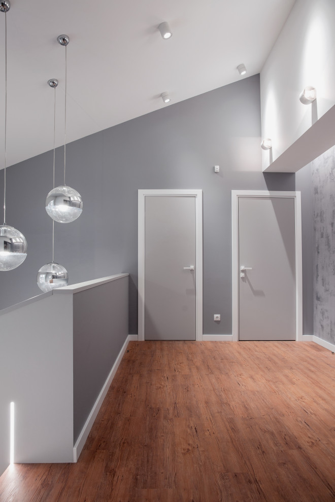 Idées déco pour un couloir contemporain de taille moyenne avec un mur gris, un sol en vinyl, un sol marron et du papier peint.