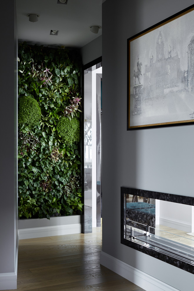 Inspiration pour un couloir traditionnel de taille moyenne avec un mur gris, un sol en bois brun et un sol beige.