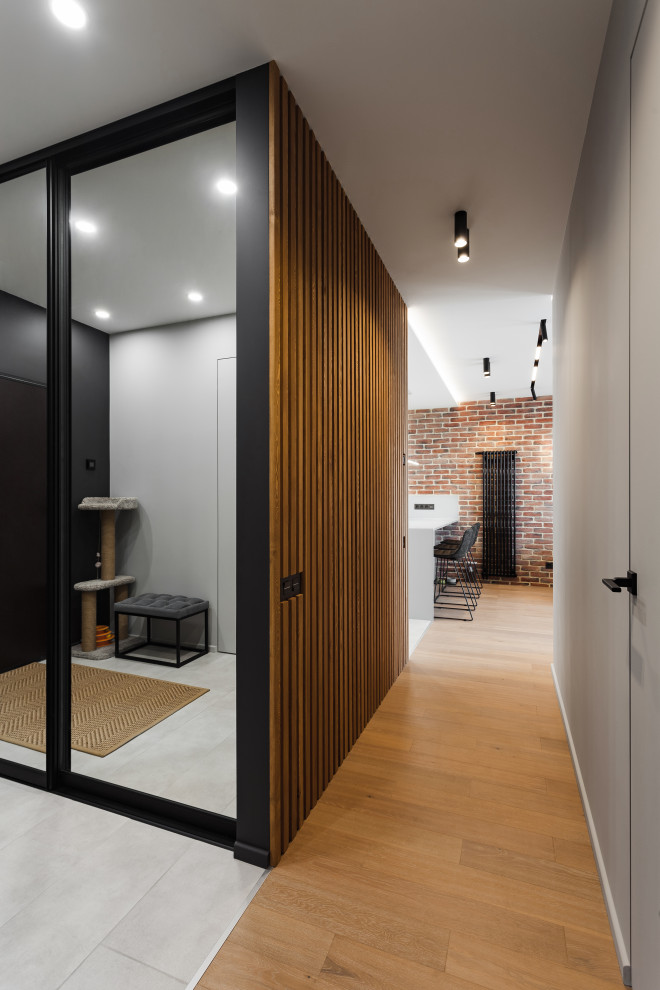 Стильный дизайн: коридор среднего размера в современном стиле с серыми стенами, полом из ламината, бежевым полом и деревянными стенами - последний тренд