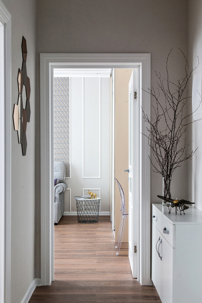 Idéer för en mellanstor minimalistisk hall, med beige väggar, laminatgolv och brunt golv