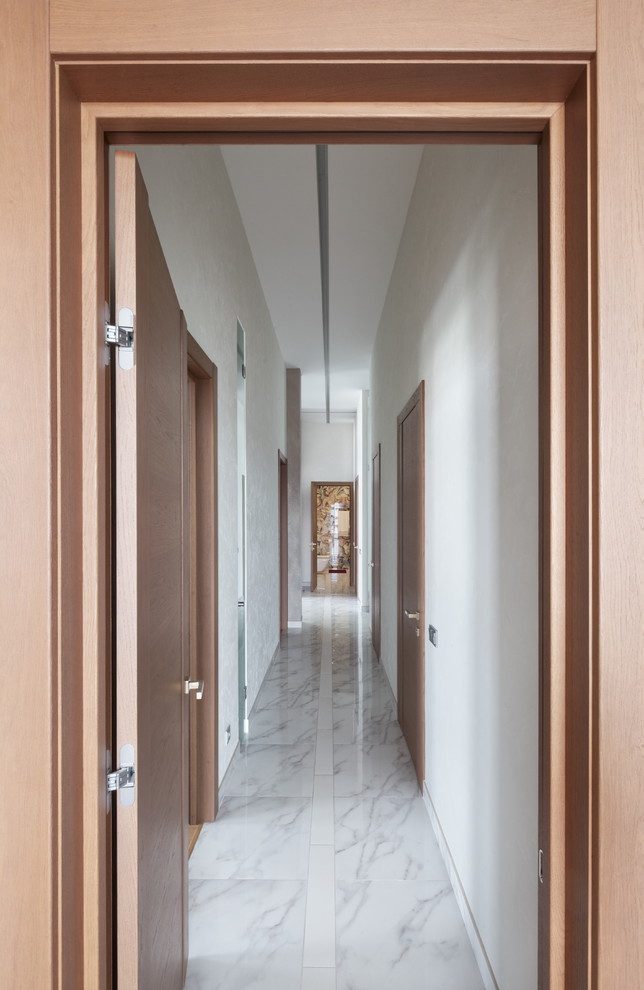 Diseño de recibidores y pasillos contemporáneos con paredes blancas y suelo blanco
