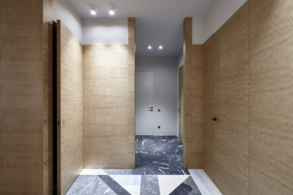 Idées déco pour un couloir contemporain de taille moyenne avec un mur beige, un sol gris et boiseries.