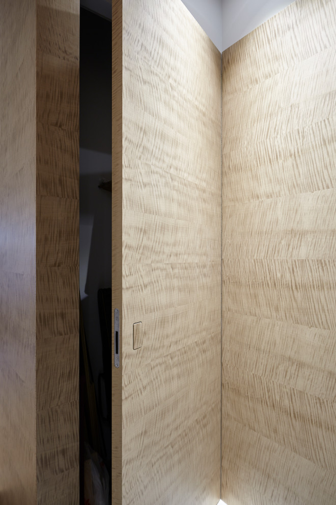 Cette image montre un couloir design de taille moyenne avec un mur beige, un sol gris et boiseries.