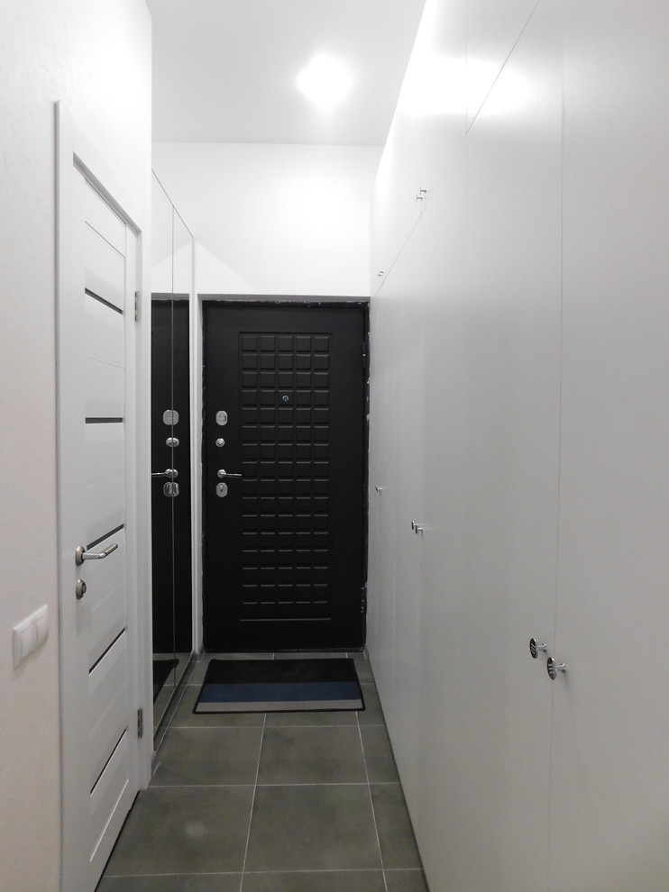 Идея дизайна: коридор среднего размера в стиле лофт с белыми стенами, кирпичным полом и серым полом