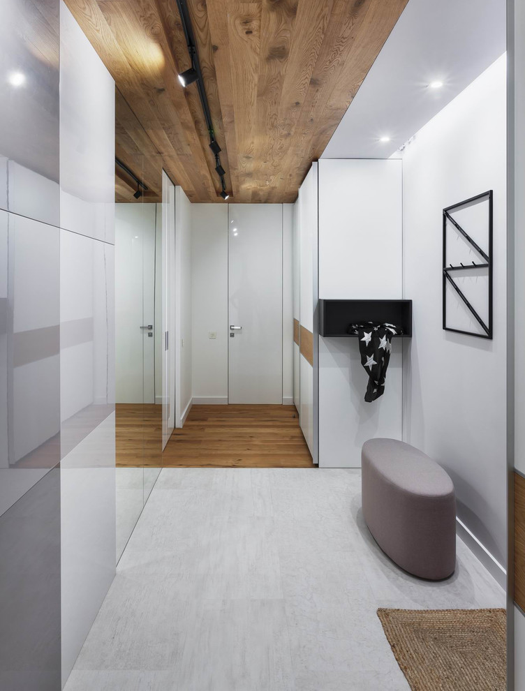 Inspiration pour un couloir design de taille moyenne avec un mur blanc, un sol en carrelage de céramique et un sol gris.