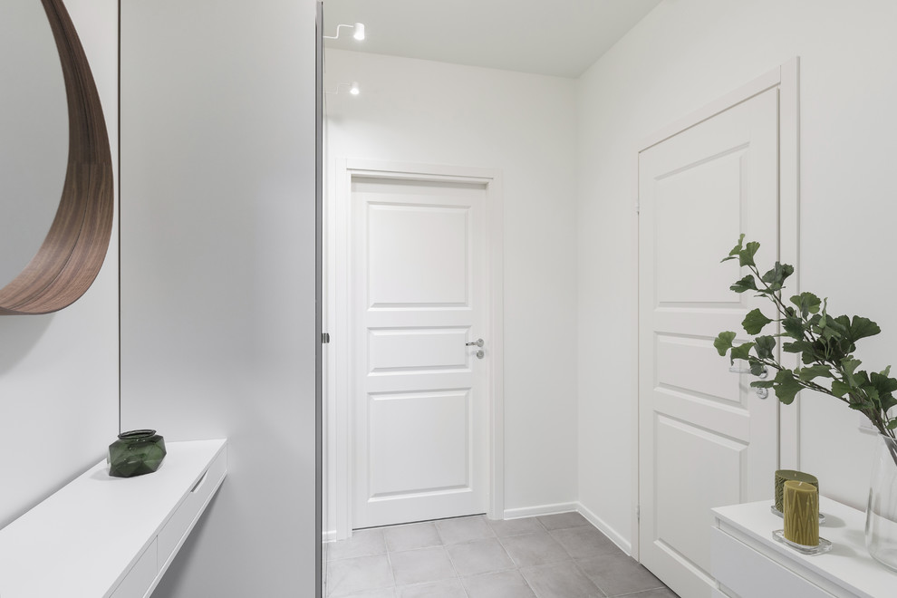 Источник вдохновения для домашнего уюта: коридор в скандинавском стиле с белыми стенами, полом из керамогранита и серым полом