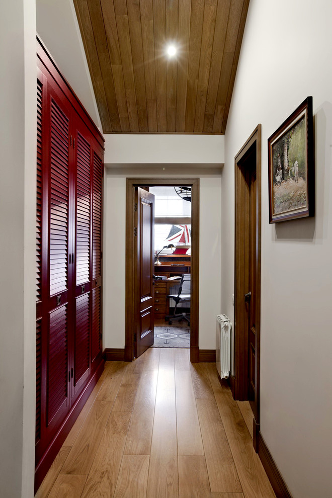 Immagine di un ingresso o corridoio chic con pareti bianche e pavimento in legno massello medio