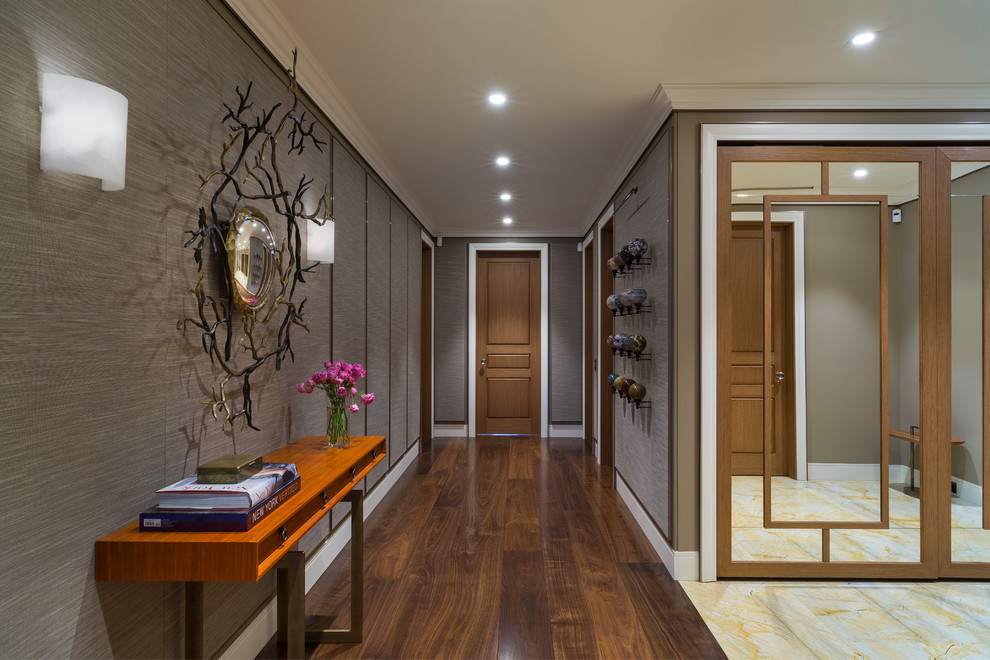 На фото: коридор в стиле неоклассика (современная классика) с серыми стенами, темным паркетным полом и коричневым полом с