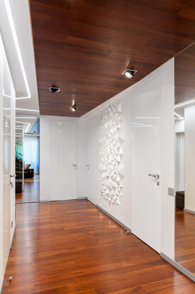 Idee per un ingresso o corridoio minimal di medie dimensioni con pareti bianche, pavimento marrone e pavimento in legno massello medio