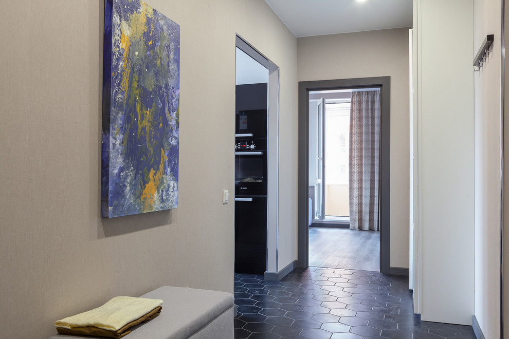 Exemple d'un couloir tendance de taille moyenne avec un mur beige, un sol en carrelage de céramique et un sol noir.
