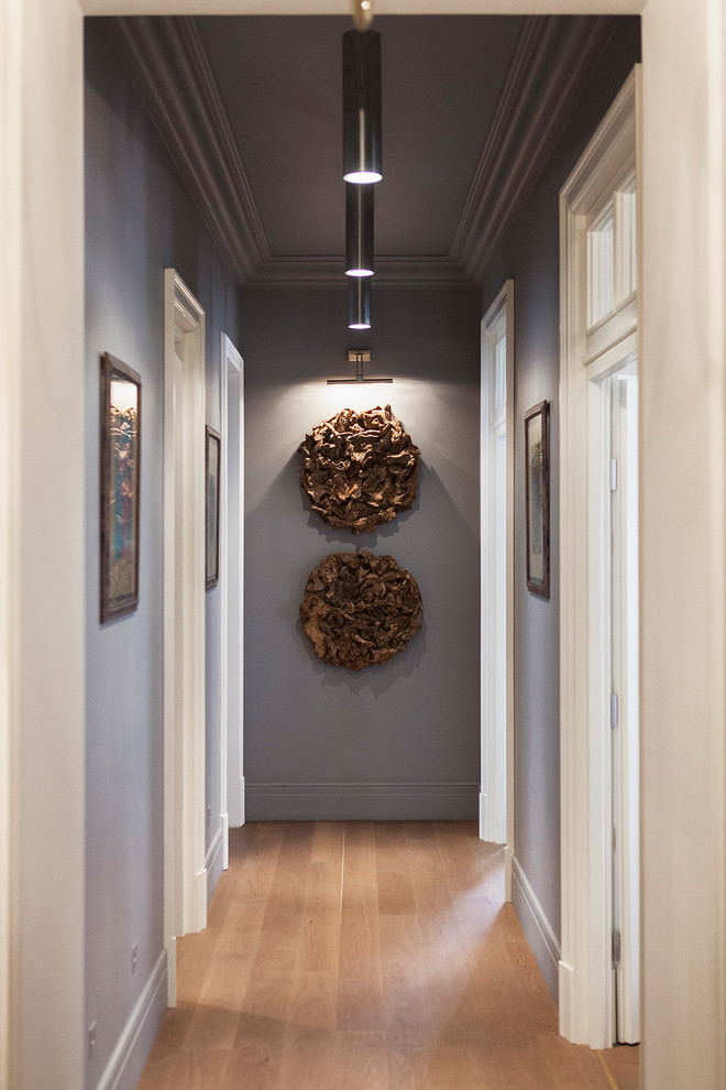 Foto de recibidores y pasillos bohemios con paredes grises y suelo de madera en tonos medios