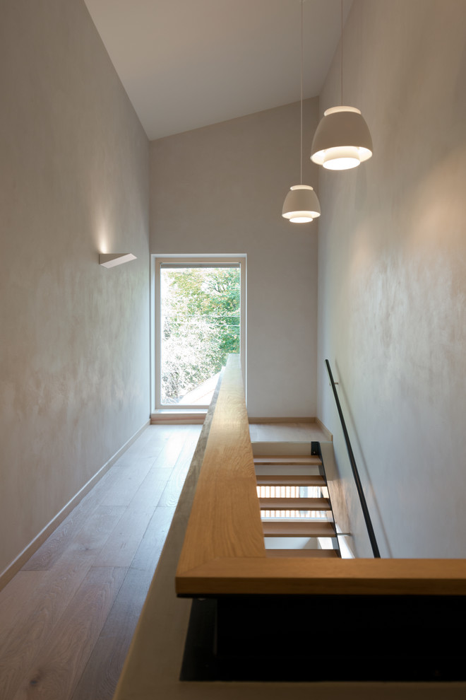 Свежая идея для дизайна: коридор среднего размера: освещение в современном стиле с белыми стенами, светлым паркетным полом и бежевым полом - отличное фото интерьера