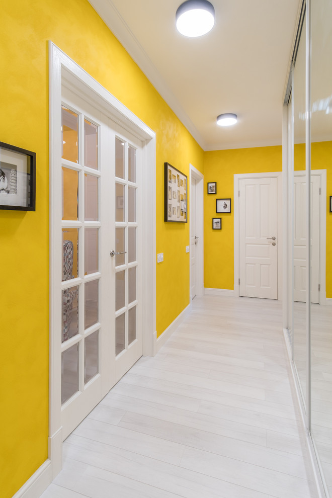 Пример оригинального дизайна: коридор: освещение в стиле неоклассика (современная классика) с желтыми стенами, белым полом и деревянным полом
