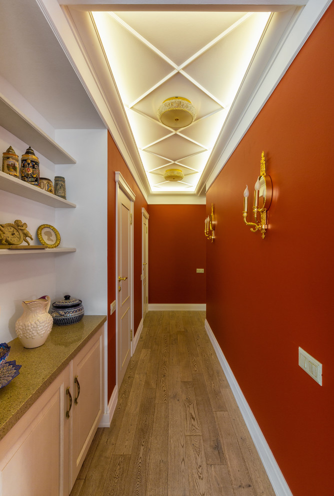 Пример оригинального дизайна: коридор в стиле неоклассика (современная классика) с красными стенами, паркетным полом среднего тона и коричневым полом