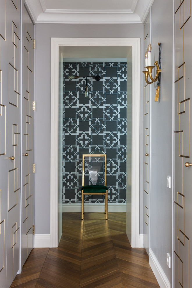На фото: коридор в стиле неоклассика (современная классика) с серыми стенами, паркетным полом среднего тона и коричневым полом с