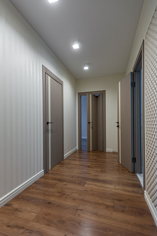 Ispirazione per un ingresso o corridoio minimal con pareti bianche e pavimento in laminato