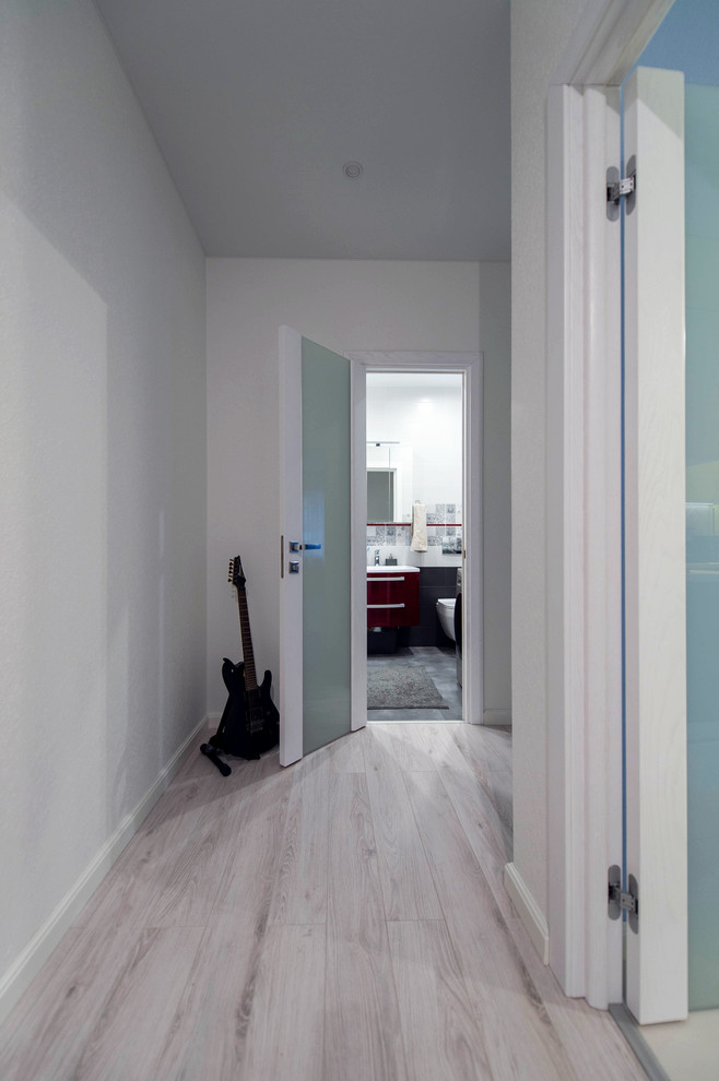 Foto de recibidores y pasillos contemporáneos pequeños con paredes blancas, suelo de baldosas de porcelana y suelo gris