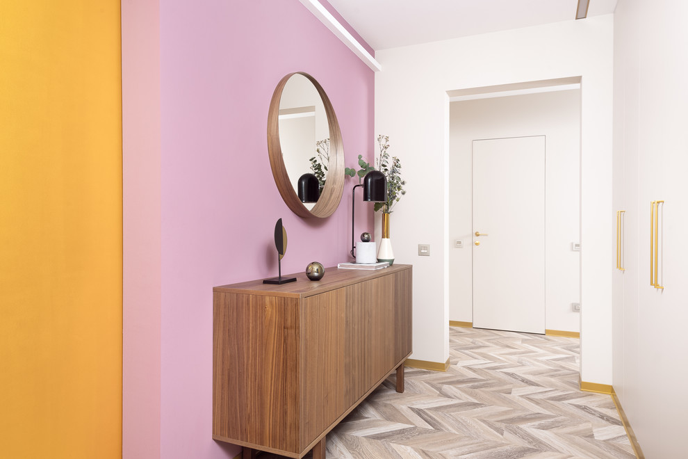 Ispirazione per un ingresso o corridoio design di medie dimensioni con pareti rosa, pavimento in laminato e pavimento beige