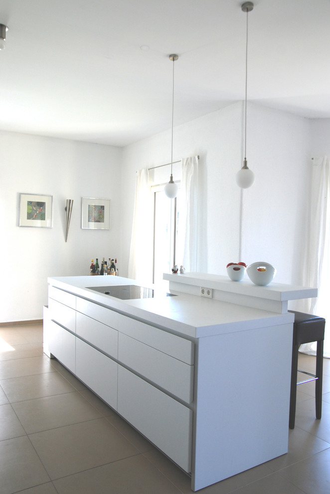 Diseño de cocina contemporánea con armarios con paneles lisos, puertas de armario blancas y una isla