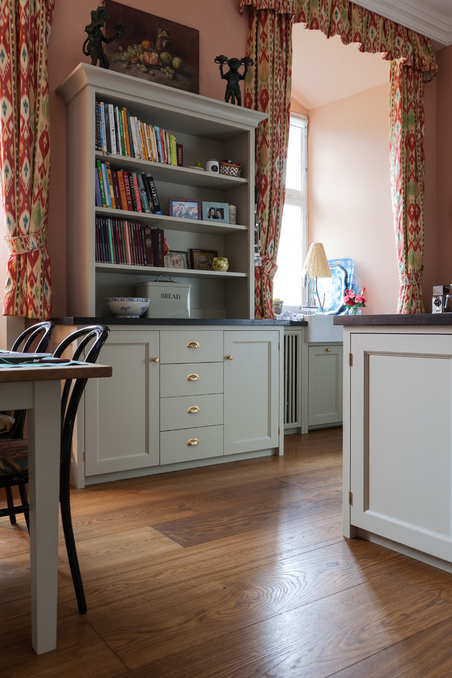 Large country l-shaped medium tone wood floor open concept kitchen photo in Cologne with a double-bowl sink, shaker cabinets, beige cabinets, granite countertops, pink backsplash, subway tile backsplash, colored appliances and an island
