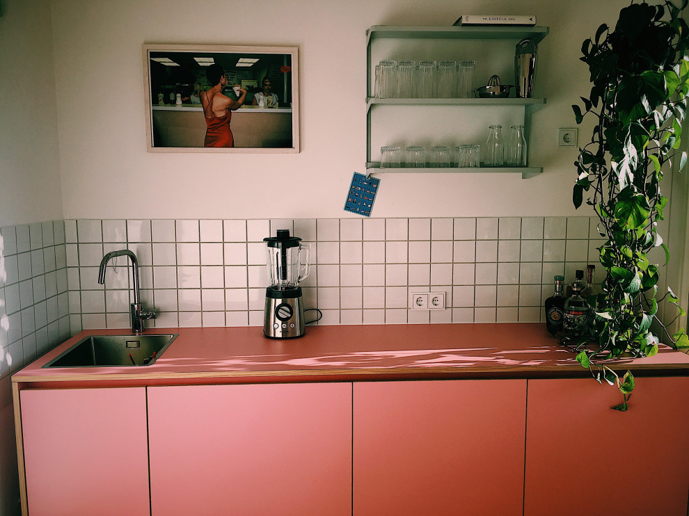 Inspiration pour une petite cuisine linéaire design fermée avec une crédence blanche, aucun îlot et un plan de travail rose.