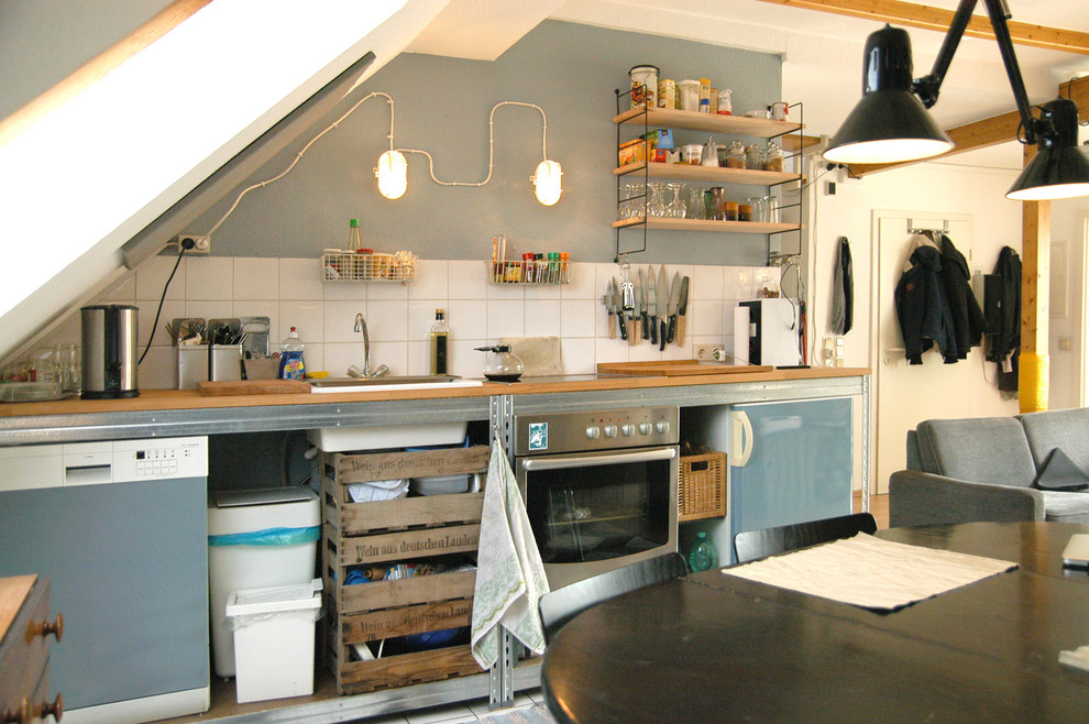 ドルトムントにある中くらいなコンテンポラリースタイルのおしゃれなキッチン (ドロップインシンク、オープンシェルフ、木材カウンター、青いキッチンパネル、セラミックタイルのキッチンパネル、シルバーの調理設備、アイランドなし) の写真