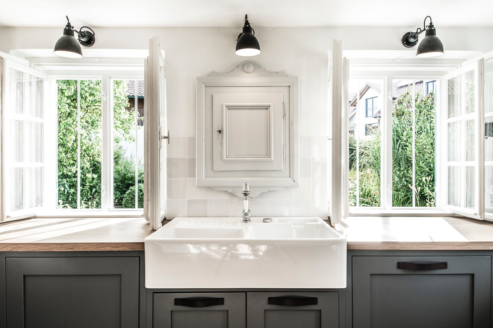 Modelo de cocina nórdica con armarios con rebordes decorativos y puertas de armario grises