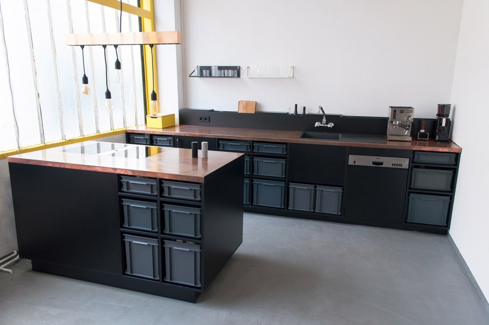 Пример оригинального дизайна: прямая кухня-гостиная среднего размера в стиле лофт с накладной мойкой, черными фасадами, столешницей из меди, белым фартуком, черной техникой, бетонным полом и островом