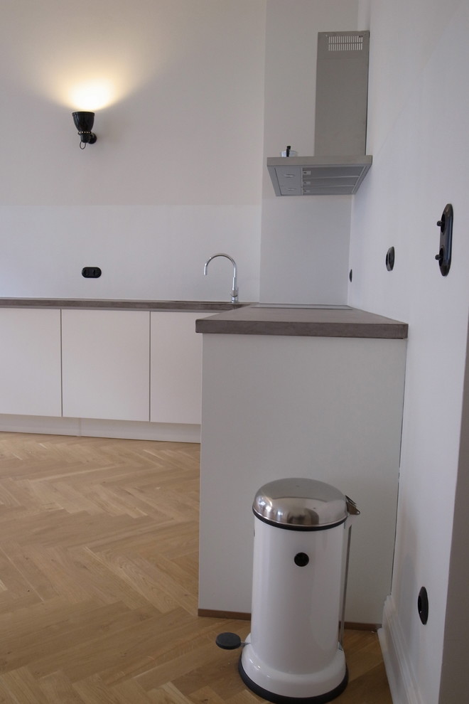 На фото: угловая кухня среднего размера в современном стиле с обеденным столом и столешницей из бетона