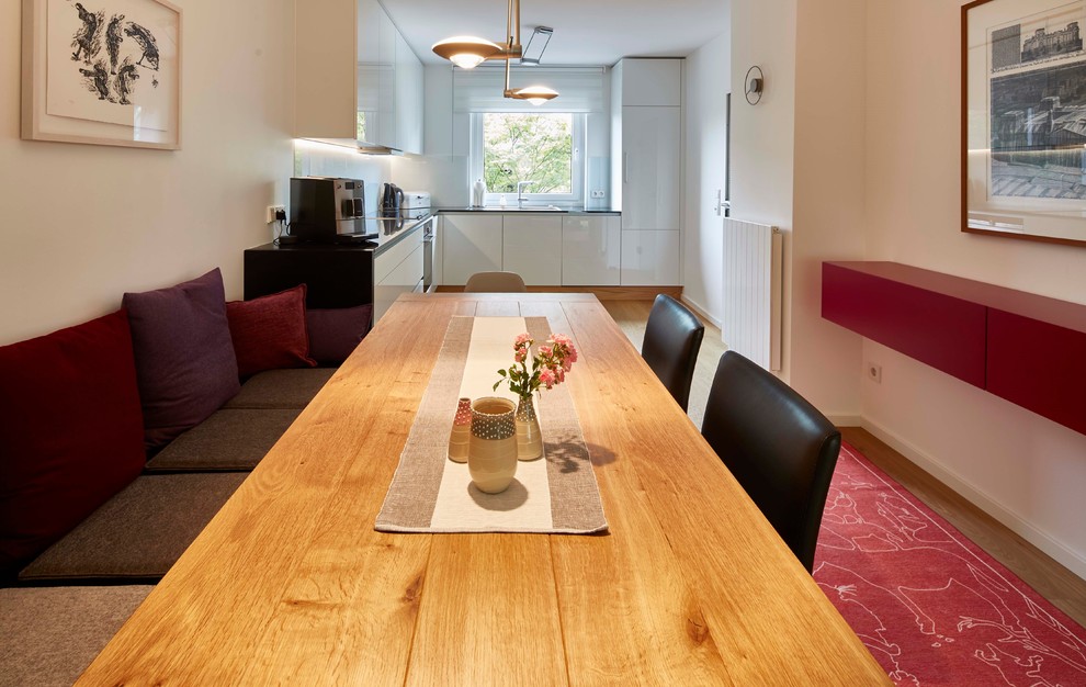 This is an example of a medium sized contemporary open plan dining room in Other with light hardwood flooring.